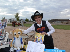 Lynda Exley shown at the Chandler Chuckwagon Cookoff with her traveling companion, Johnny Ringo, a puppet representing Arizona's State Mammal.